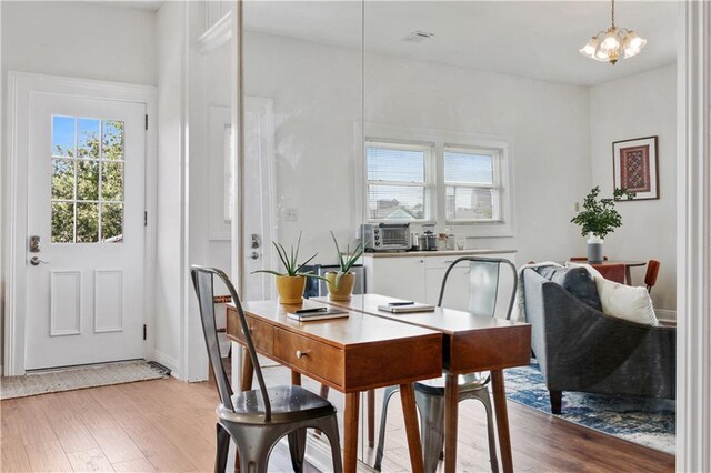 dining area featuring a notable chandelier and light wood-type flooring