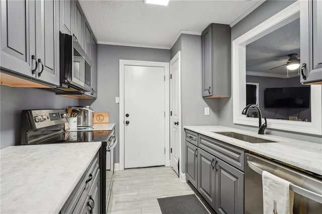 kitchen featuring gray cabinetry, a textured ceiling, appliances with stainless steel finishes, and sink