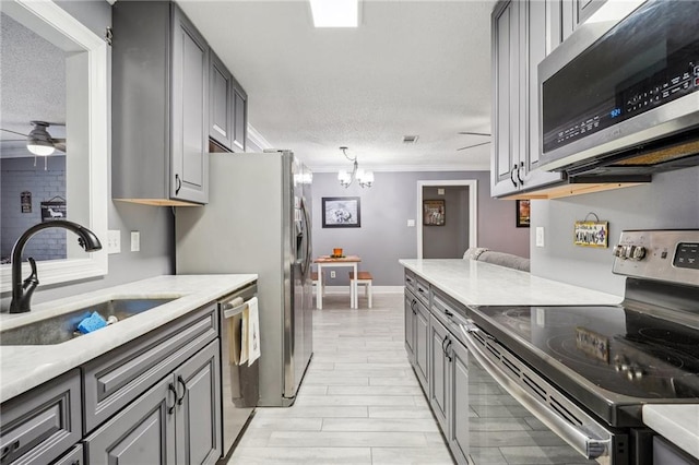 kitchen with gray cabinets, appliances with stainless steel finishes, crown molding, and sink