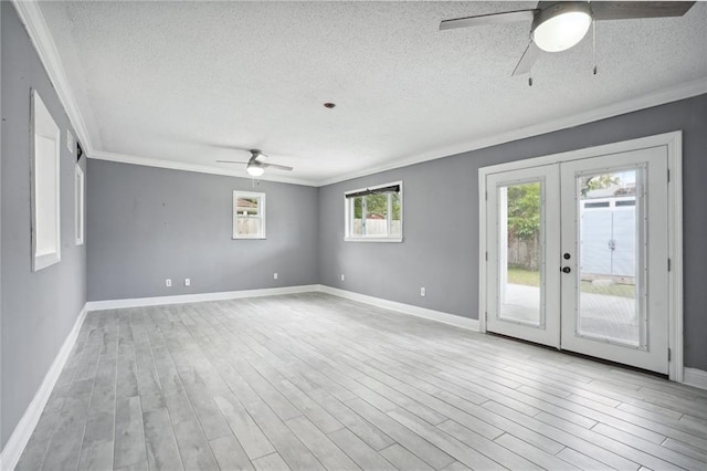 spare room with french doors, a textured ceiling, and light hardwood / wood-style floors