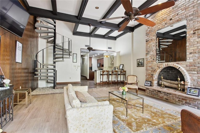 living room with a fireplace, ceiling fan, and high vaulted ceiling