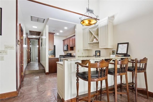 kitchen with hanging light fixtures, sink, stainless steel appliances, a breakfast bar area, and light stone countertops