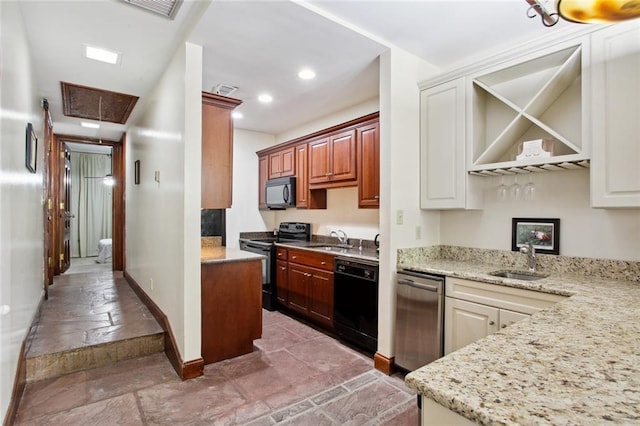 kitchen with light stone counters, sink, kitchen peninsula, and black appliances