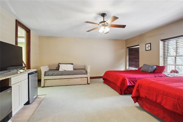 carpeted bedroom featuring ceiling fan and stainless steel refrigerator