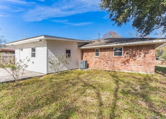 rear view of house with a lawn, a patio area, and central air condition unit