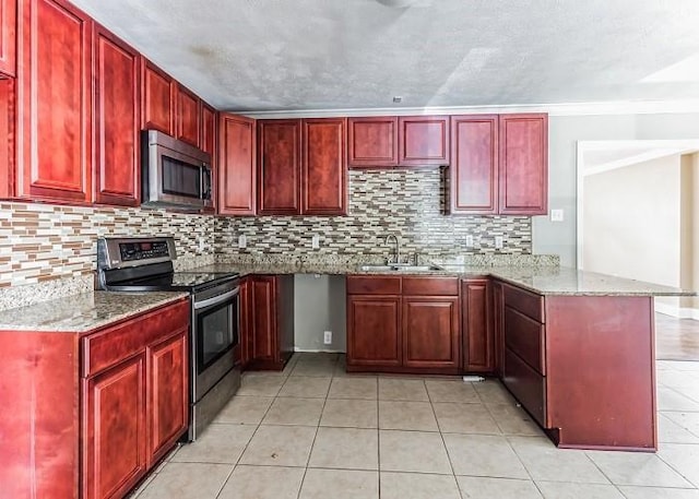 kitchen featuring decorative backsplash, light stone counters, kitchen peninsula, and appliances with stainless steel finishes