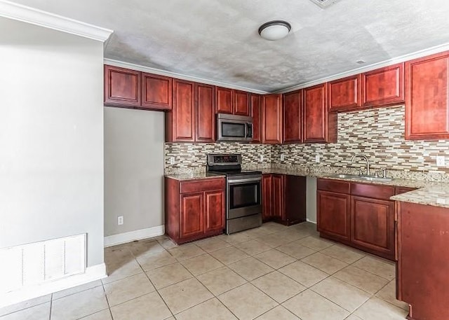 kitchen featuring light stone countertops, backsplash, appliances with stainless steel finishes, and sink