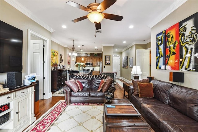 living room featuring ceiling fan, ornamental molding, and wood-type flooring