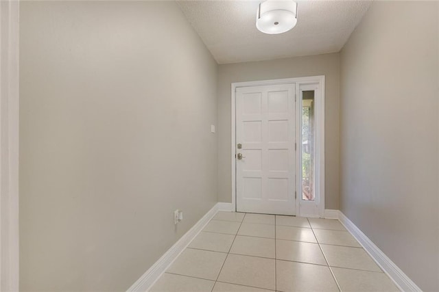 foyer entrance with a textured ceiling and light tile patterned floors