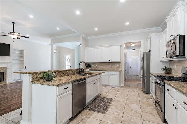 kitchen with white cabinetry, a kitchen island with sink, sink, and stainless steel appliances