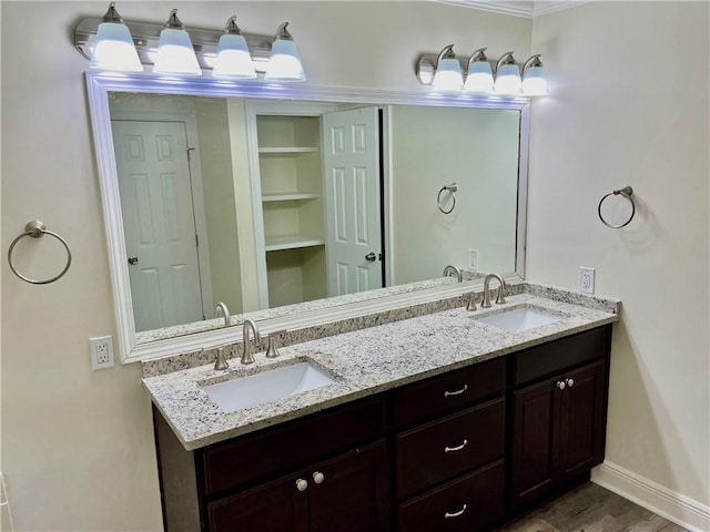 bathroom featuring ornamental molding, hardwood / wood-style flooring, and vanity