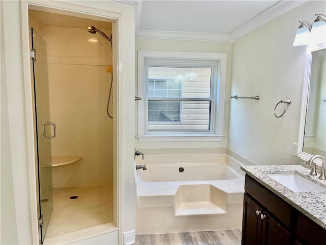 bathroom featuring plus walk in shower, hardwood / wood-style flooring, vanity, and crown molding