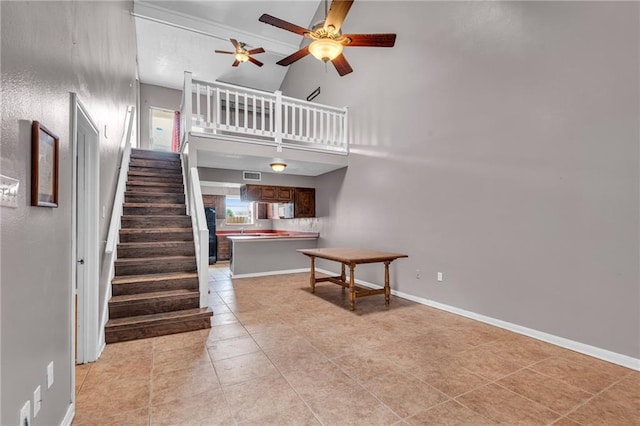 interior space featuring high vaulted ceiling, ceiling fan, and tile patterned floors