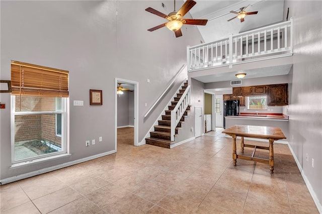 interior space with high vaulted ceiling, ceiling fan, light tile patterned floors, and sink