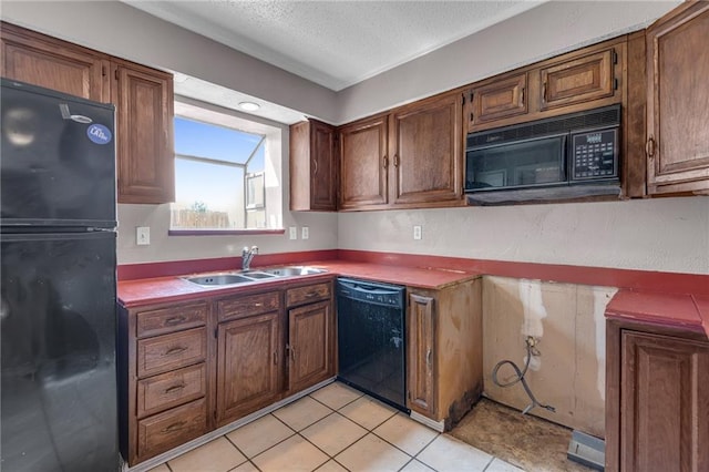 kitchen with black appliances, a textured ceiling, light tile patterned floors, and sink