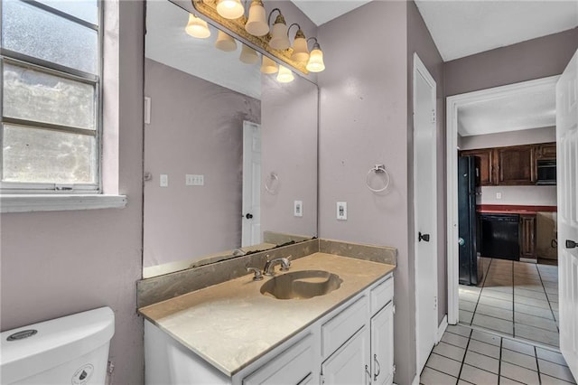 bathroom featuring tile patterned flooring, vanity, and toilet