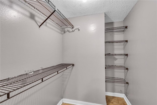 walk in closet with tile patterned floors