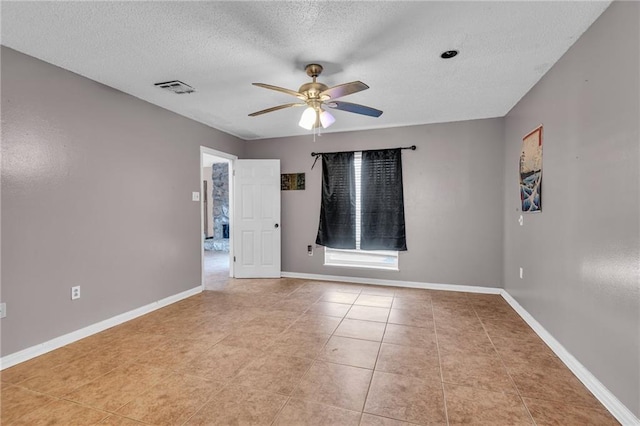 unfurnished room featuring ceiling fan, light tile patterned floors, and a textured ceiling