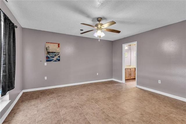 empty room with a textured ceiling, light tile patterned floors, and ceiling fan