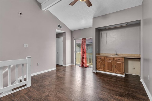 unfurnished living room with beam ceiling, dark hardwood / wood-style flooring, ceiling fan, and high vaulted ceiling