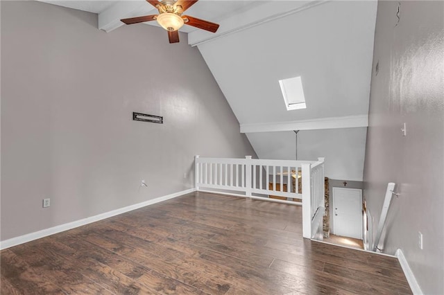 interior space featuring vaulted ceiling with skylight, ceiling fan, and dark hardwood / wood-style flooring