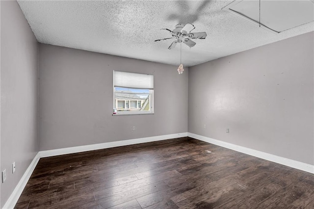 empty room with a textured ceiling, dark hardwood / wood-style floors, and ceiling fan