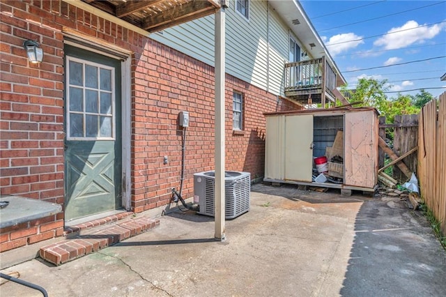 view of patio / terrace with a storage shed and central air condition unit