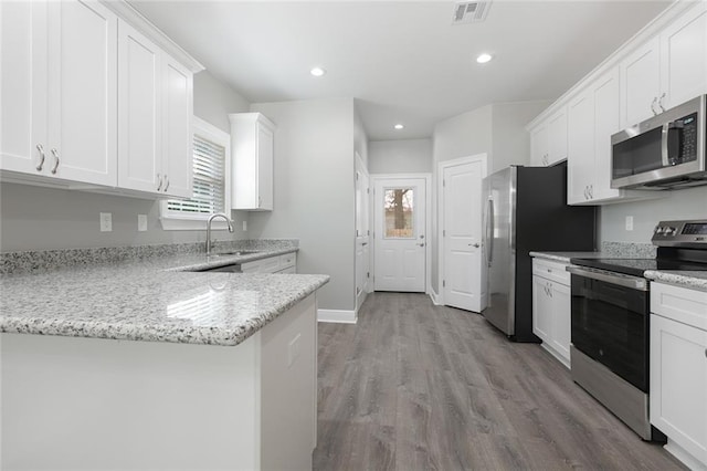 kitchen featuring light stone countertops, white cabinets, and stainless steel appliances