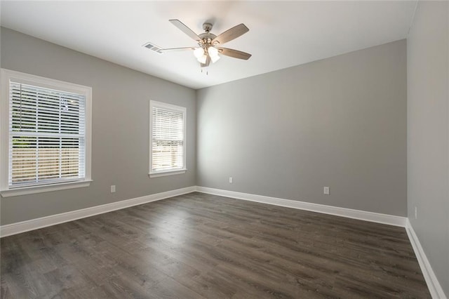 empty room featuring dark wood-type flooring and ceiling fan