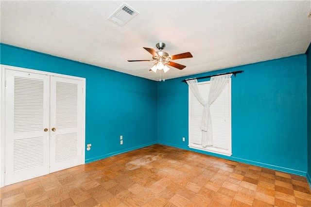 spare room with ceiling fan and light parquet flooring