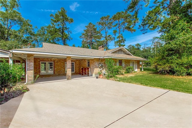 view of front facade with a front lawn, french doors, and a patio area