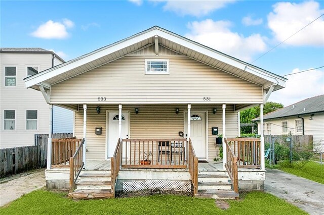 531-33 S Murat St, New Orleans, LA 70119 - shotgun-style home featuring a porch and fence