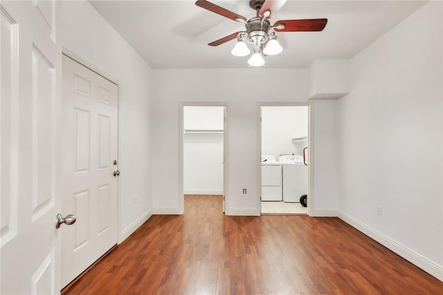531-33 S Murat St, New Orleans, LA 70119 - unfurnished bedroom featuring baseboards, wood finished floors, a spacious closet, and washer and dryer