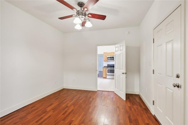 unfurnished bedroom featuring ceiling fan and dark hardwood / wood-style floors