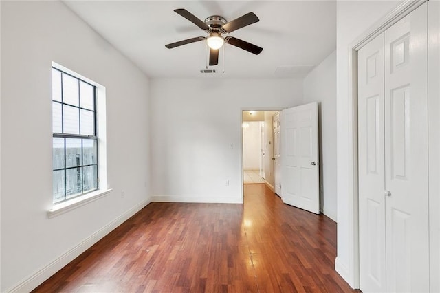 unfurnished bedroom with a closet, ceiling fan, and dark hardwood / wood-style flooring