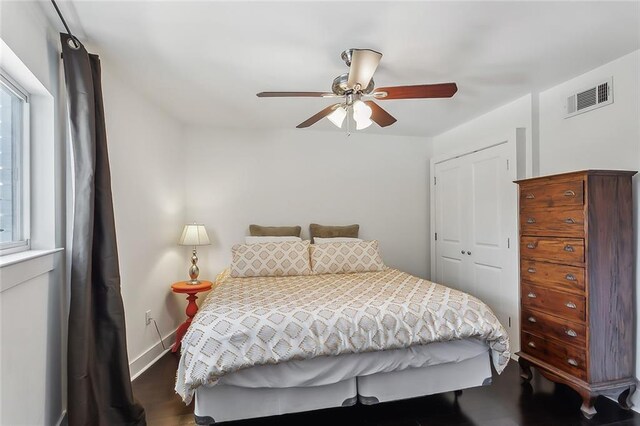 bedroom with ceiling fan, dark hardwood / wood-style floors, and a closet