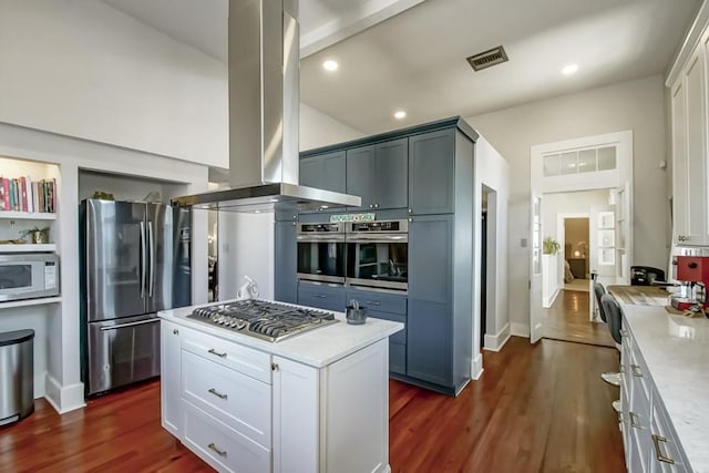 kitchen with white cabinets, dark hardwood / wood-style flooring, island exhaust hood, and appliances with stainless steel finishes