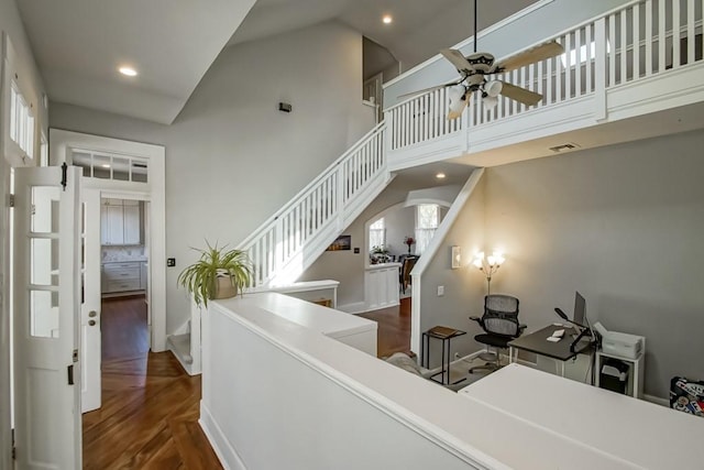 interior space with wood-type flooring, high vaulted ceiling, ceiling fan, and plenty of natural light