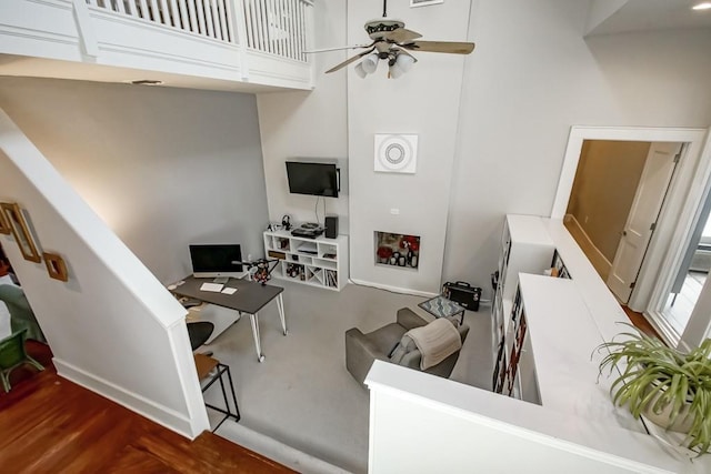 living room featuring a towering ceiling and ceiling fan