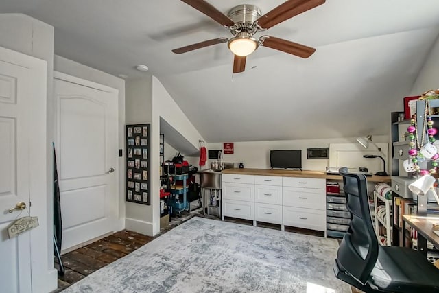 office space featuring dark hardwood / wood-style floors, ceiling fan, and vaulted ceiling