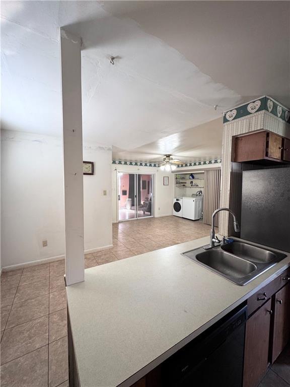 kitchen featuring sink, ceiling fan, dark brown cabinets, independent washer and dryer, and light tile patterned flooring