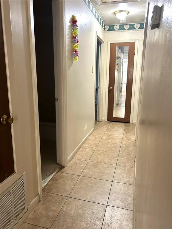 hall featuring light tile patterned flooring