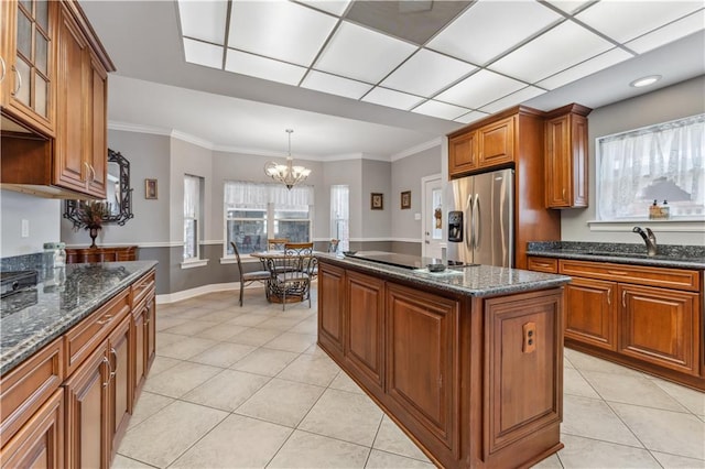 kitchen with a center island, light tile patterned flooring, sink, stainless steel refrigerator with ice dispenser, and an inviting chandelier