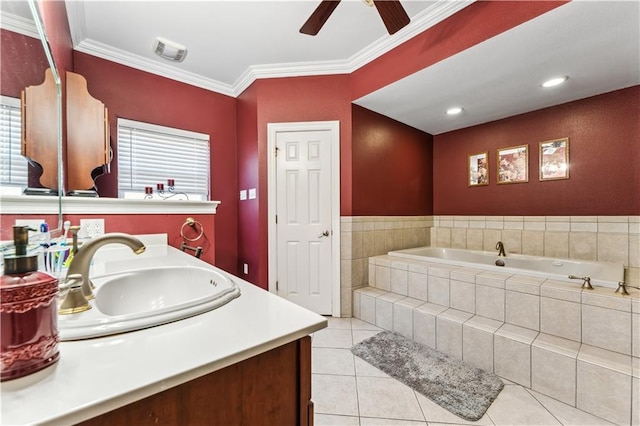 bathroom with tiled tub, tile patterned floors, ornamental molding, ceiling fan, and vanity