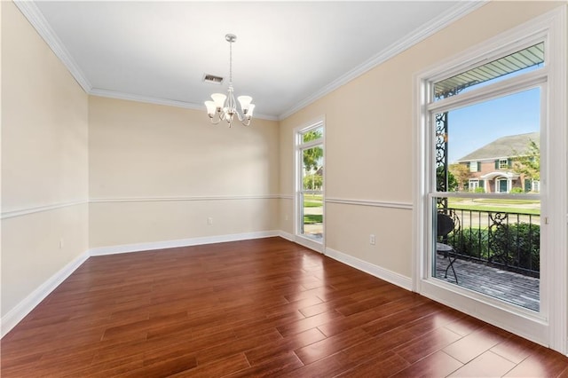 spare room featuring an inviting chandelier, crown molding, and dark hardwood / wood-style floors