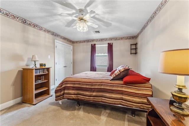 bedroom with a closet, ceiling fan, and light colored carpet