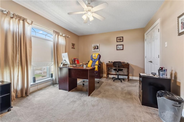 office space with ceiling fan, a textured ceiling, and light carpet