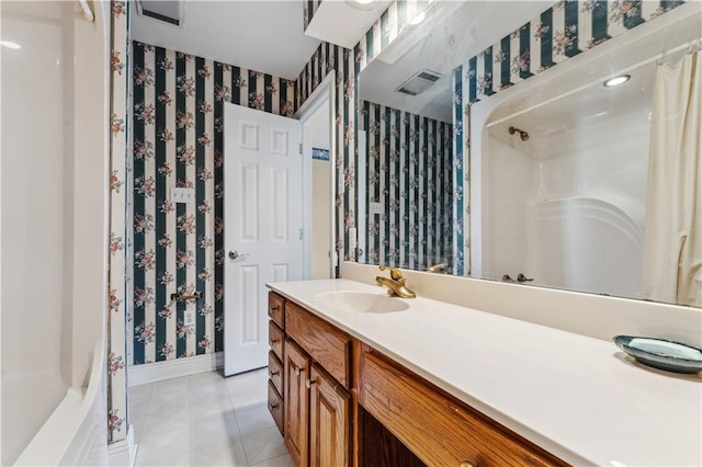 bathroom with tile patterned flooring, walk in shower, and vanity