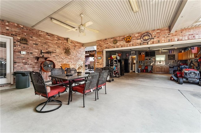 interior space with ceiling fan and brick wall