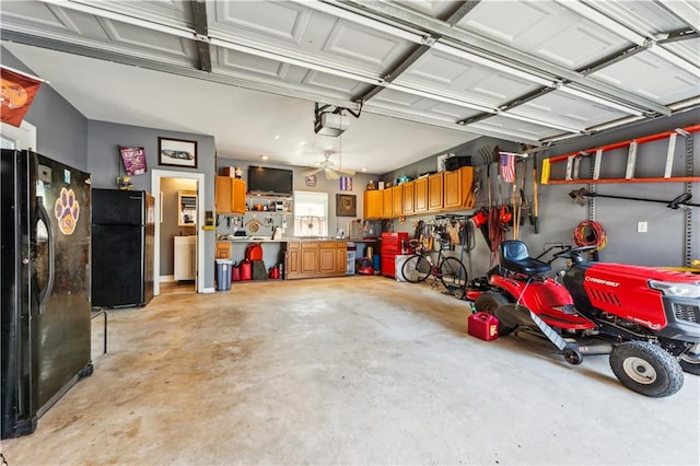 garage with a garage door opener, a workshop area, and black refrigerator